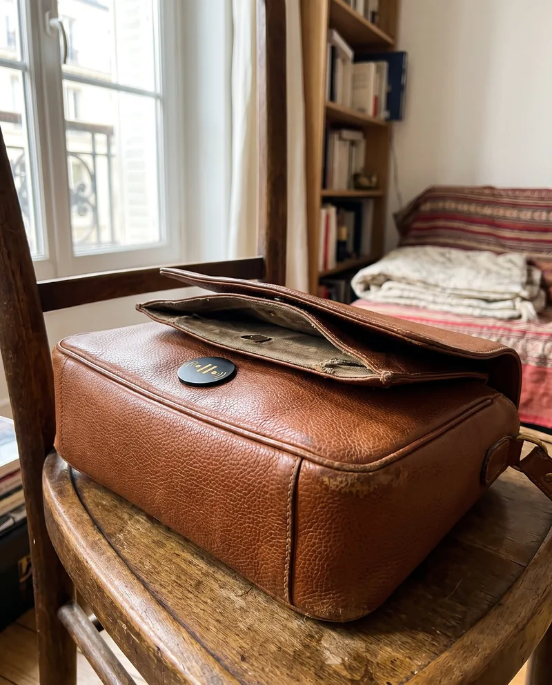 A leather bag on a chair, a Seal on its flap